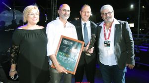 ראש העיר עכו, מר שמעון לנקרי, עם מנכל פסטיבל עכו מר אלברט בן שלוש מעניקים עיטור יקיר הפסטיבל למר ג׳קי בכר | עיבוד צילום: שולי סונגו ©