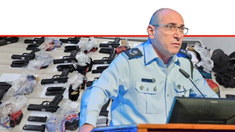 ניצב יגאל בן שלום ראש אגף חקירות ומודיעין ברקע: שלל אקדחים שנתפסו בגבולות המדינה | צילומים: דוברות המשטרה | עיבוד צילום: שולי סונגו ©