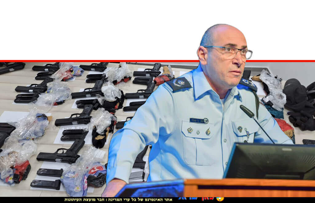 ניצב יגאל בן שלום ראש אגף חקירות ומודיעין ברקע: שלל אקדחים שנתפסו בגבולות המדינה | צילומים: דוברות המשטרה | עיבוד צילום: שולי סונגו ©
