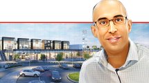 הראל שרעבי ראש חטיבת כספים ורכש של "שירותי בריאות לאומית" ברקע: מגדל עיר ג'י ראשון לציון צילום: WAWA – תכנון בר קיימא ואדריכלות ירוקה | עיבוד: בינה מלאכותית של עPhotolab | עיבוד צילום: שולי סונגו©