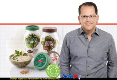 יובל מלאך, סמנכ"ל השיווק והמכירות של חב' אחוה, צנצנות טחינה גולמית של "אחוה המכסים פונים קדימה ומציגים בבירור המדבקות החדשות והסימון הירוק של משרד הבריאות | עיבוד: Gemini Google | עיצוב: שולי סונגו©