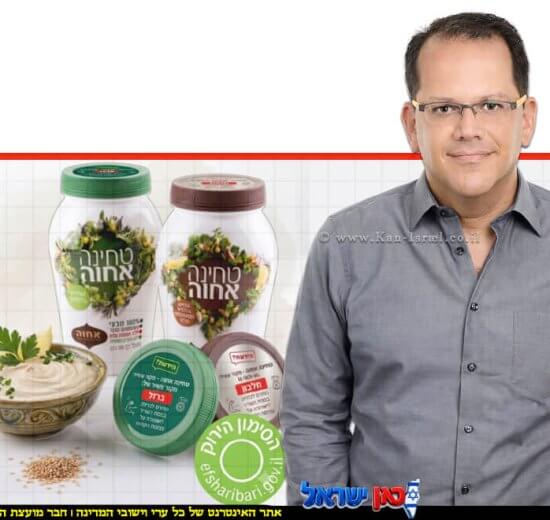 יובל מלאך, סמנכ"ל השיווק והמכירות של חב' אחוה, צנצנות טחינה גולמית של "אחוה המכסים פונים קדימה ומציגים בבירור המדבקות החדשות והסימון הירוק של משרד הבריאות | עיבוד: Gemini Google | עיצוב: שולי סונגו©