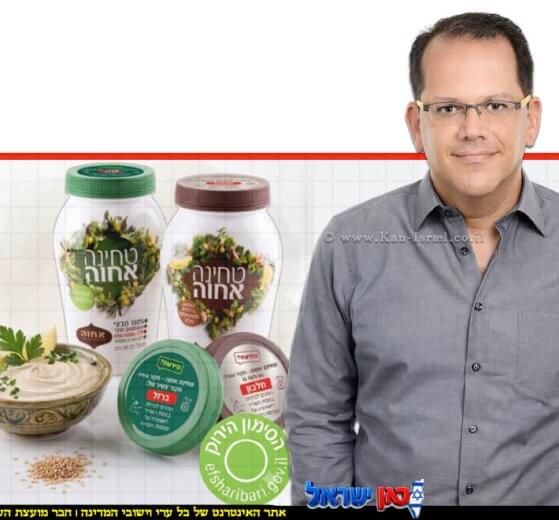 יובל מלאך, סמנכ"ל השיווק והמכירות של חב' אחוה, צנצנות טחינה גולמית של "אחוה המכסים פונים קדימה ומציגים בבירור המדבקות החדשות והסימון הירוק של משרד הבריאות | עיבוד: Gemini Google | עיצוב: שולי סונגו©